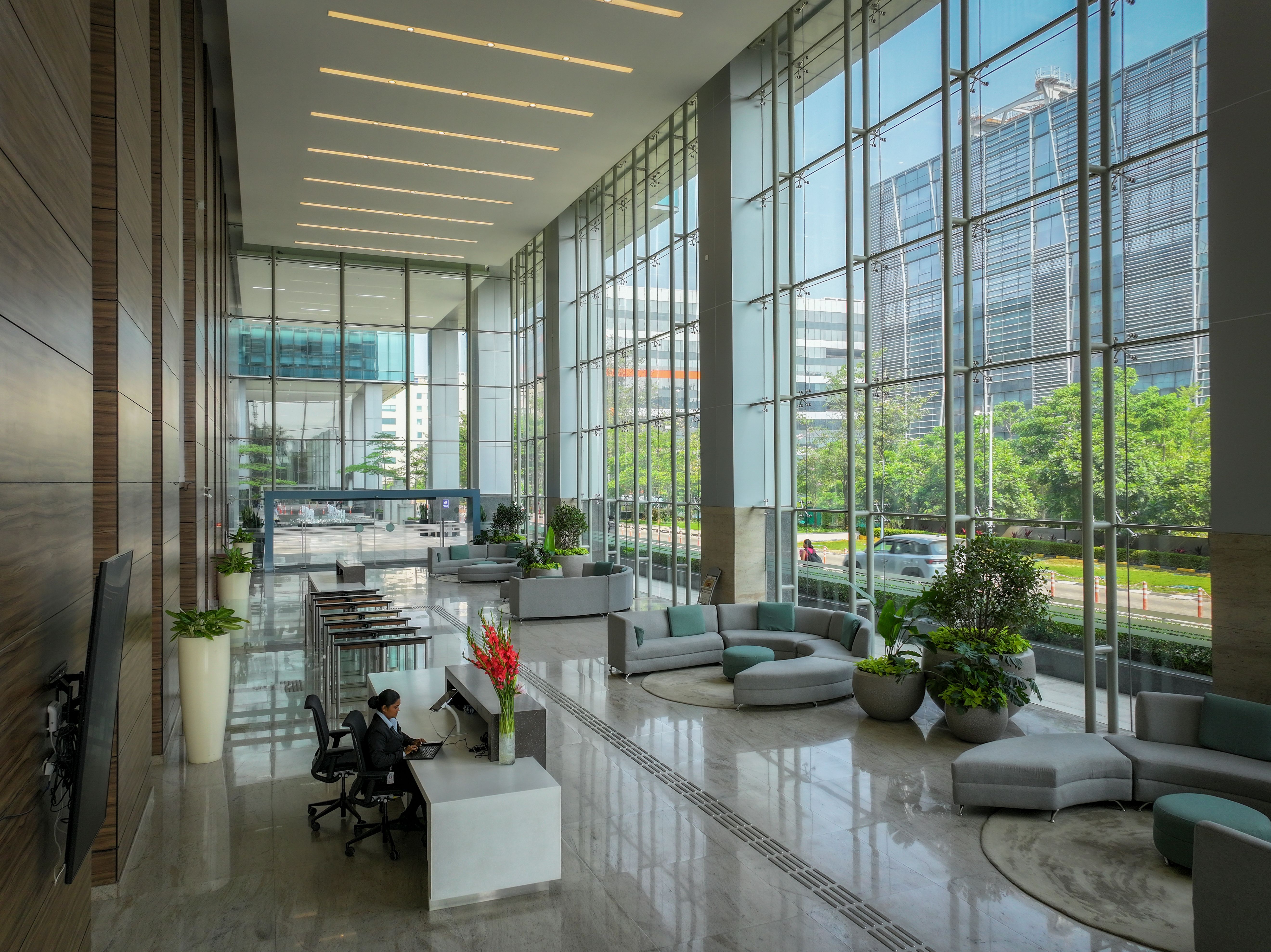 Modern office space with expansive windows offering scenic outdoor views. Workplace design, natural light, urban setting.