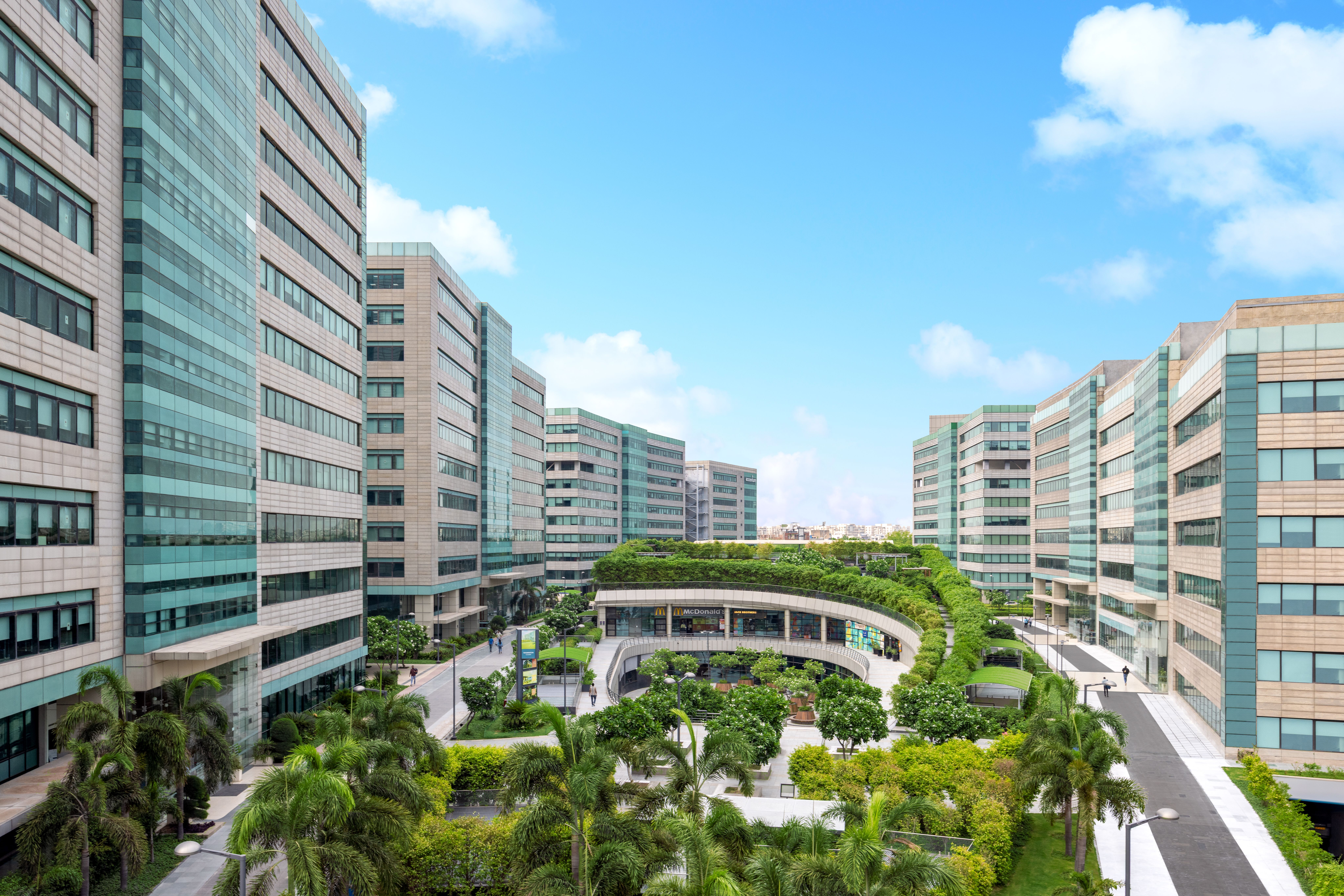 Modern office building exterior with glass facade and landscaping. Commercial real estate.