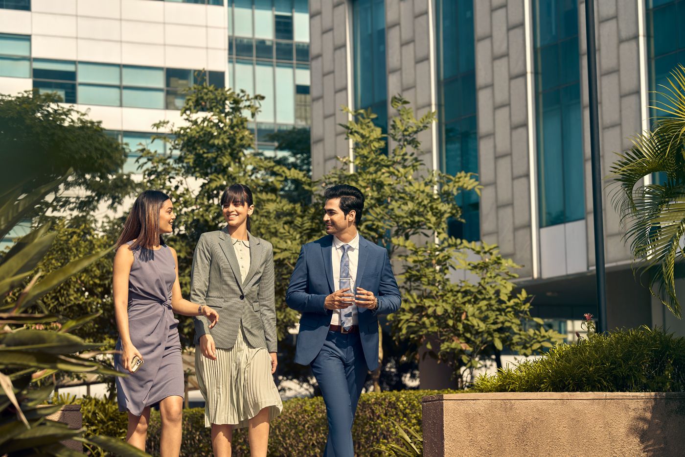 Modern office building exterior with glass facade and lush landscaping.