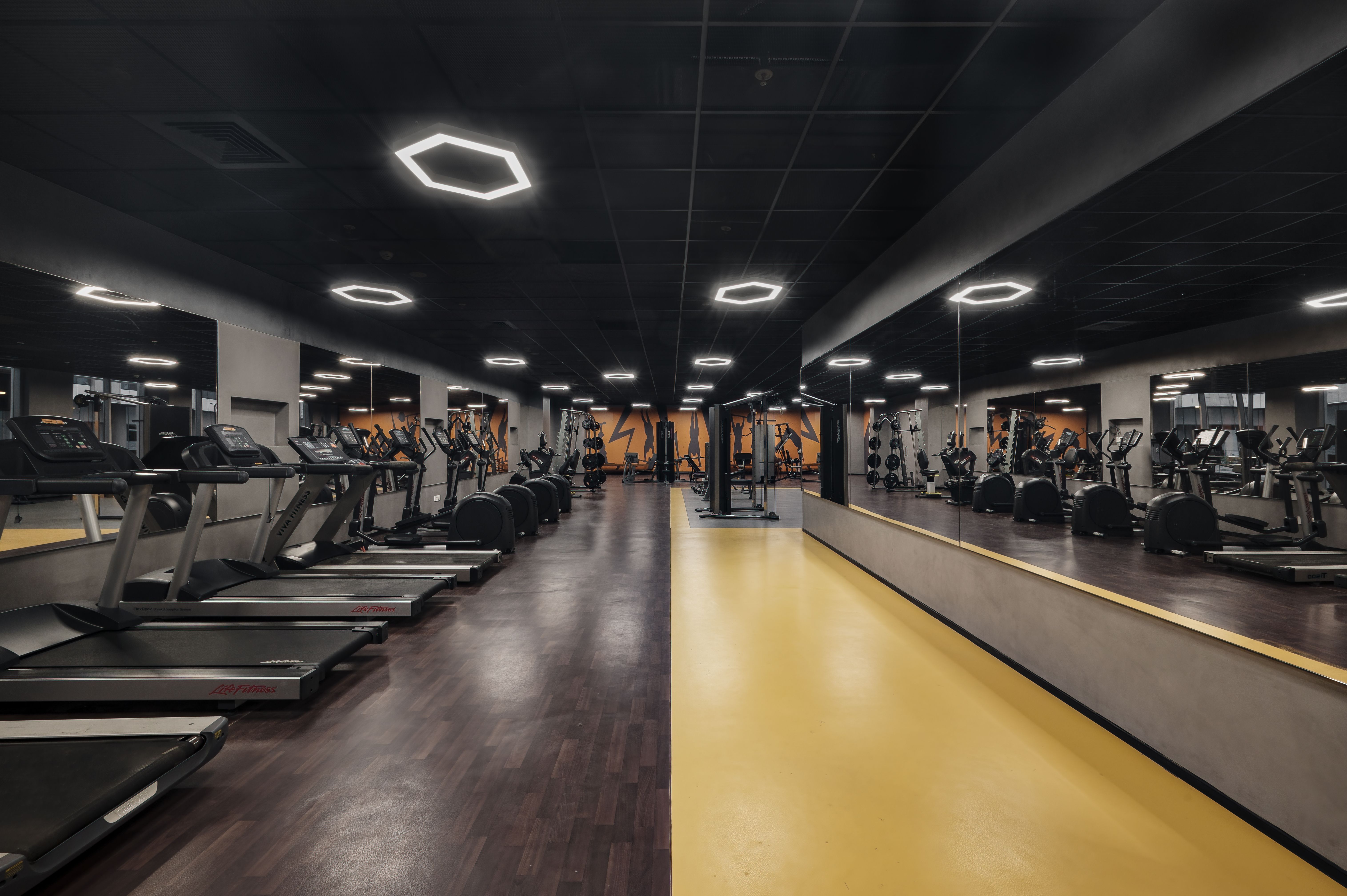 Modern gymnasium with fitness equipment and natural light, ideal for residents.