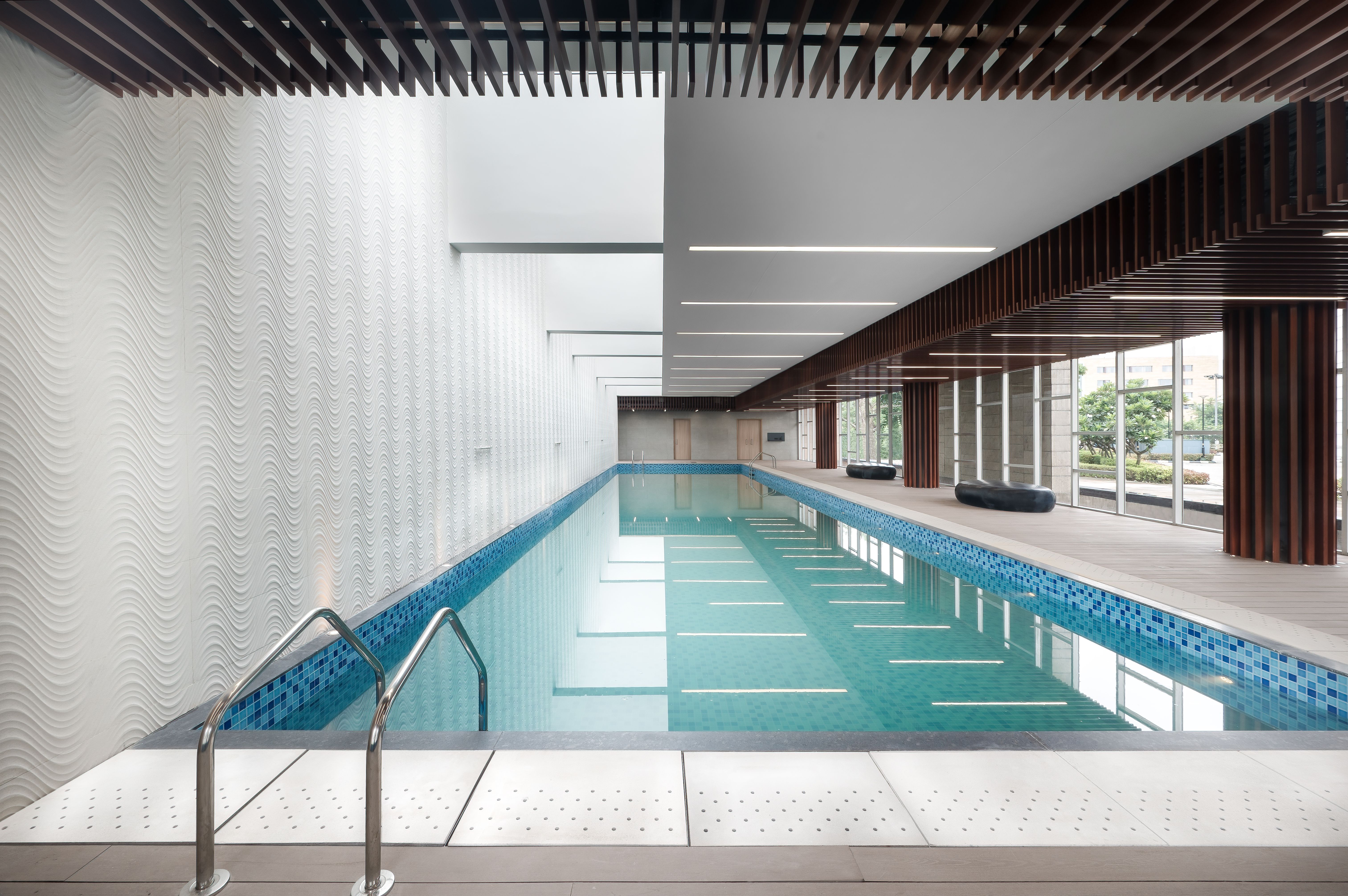 Indoor swimming pool with natural light, luxury resort style, Brookfield India REIT property.
