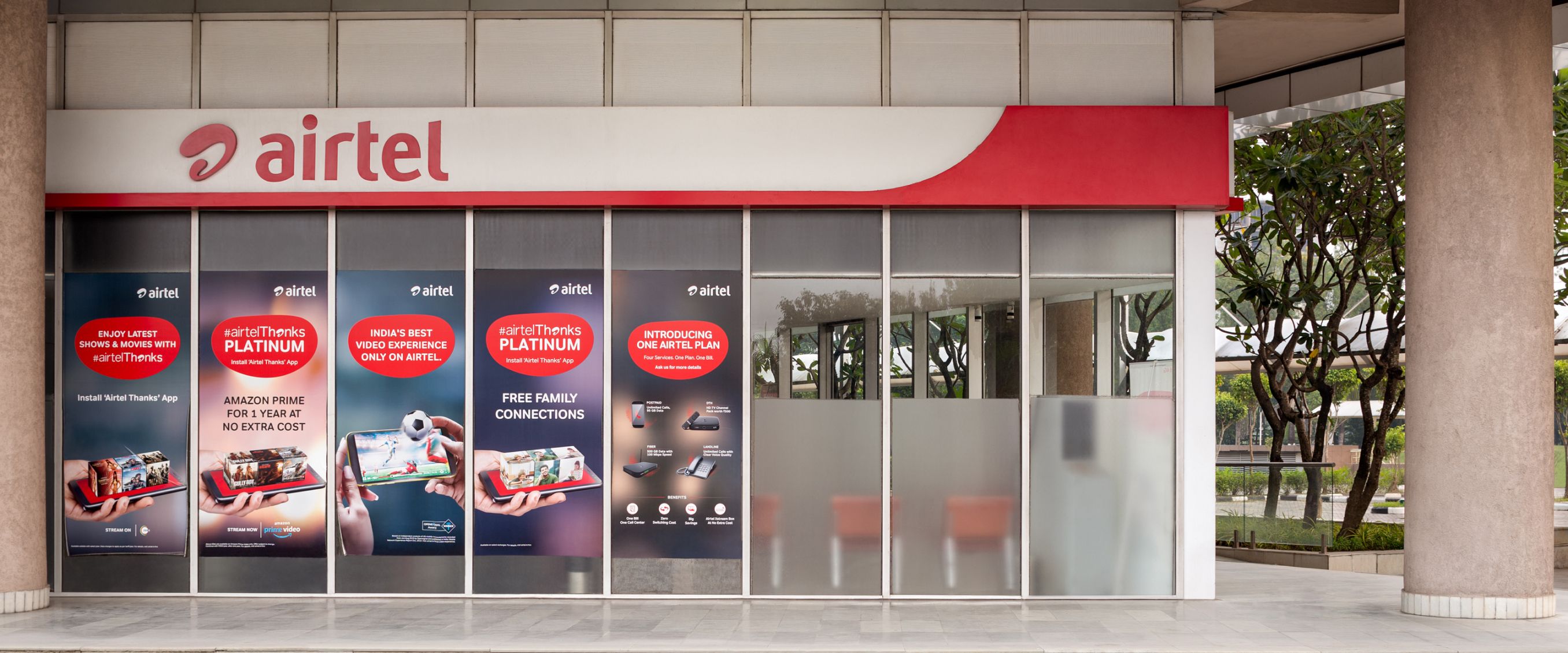 Modern retail space with shoppers browsing stores, bright and airy atmosphere.