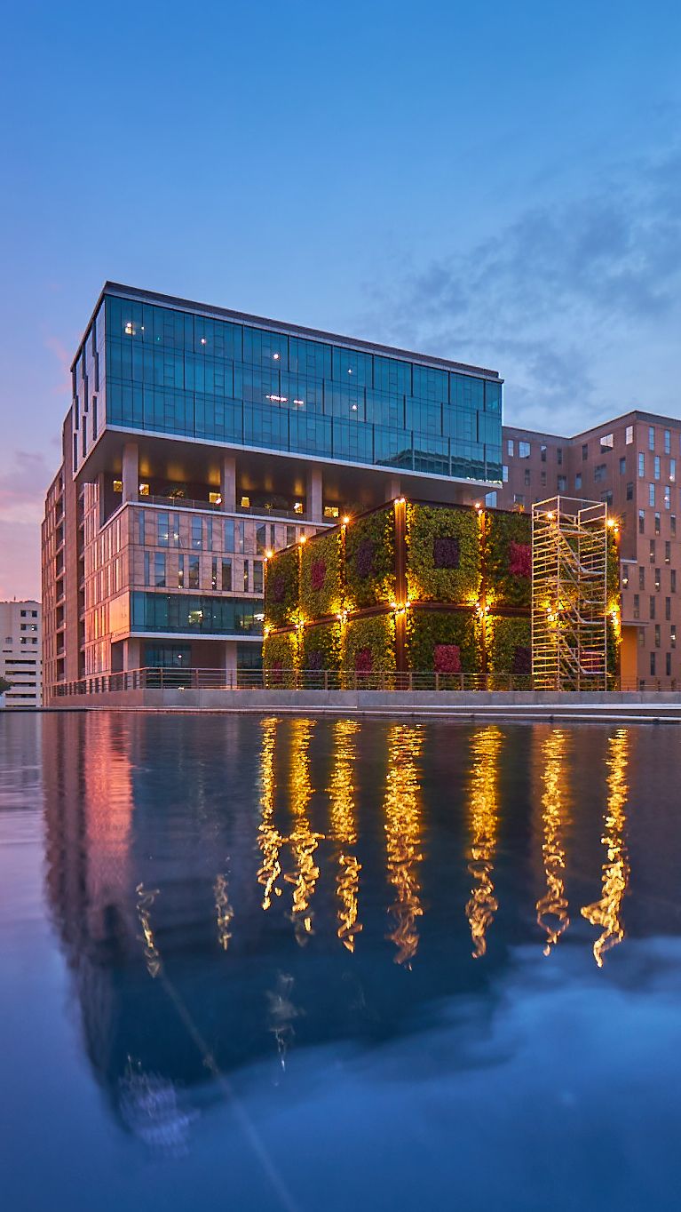 Modern office building exterior, lush greenery, sustainable design, Brookfield India REIT.