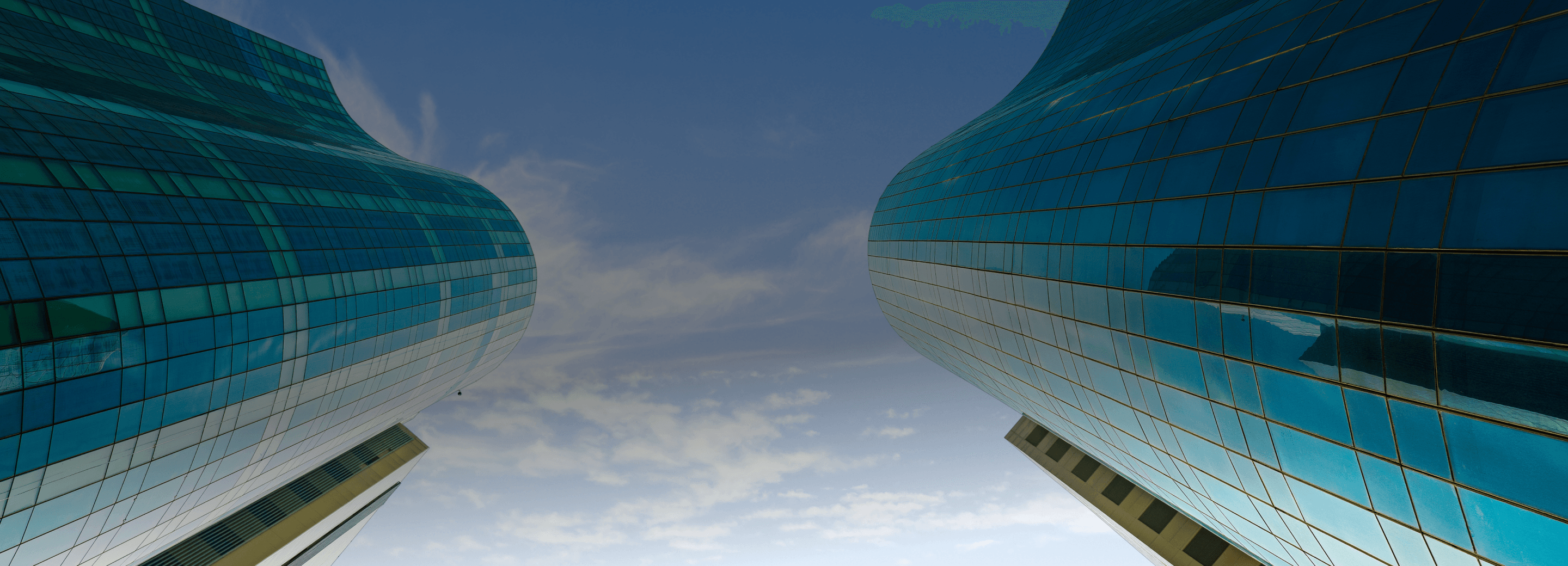 Modern office building exterior with glass facade and lush landscaping.